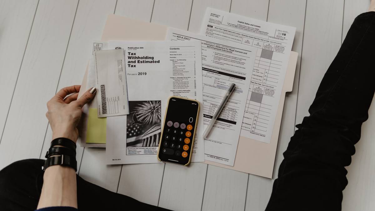 Bills, forms and a calculator laid out on a desk
